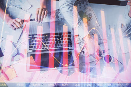 Double exposure of man and woman working together and financial graph hologram. Business concept. Computer background.の写真素材