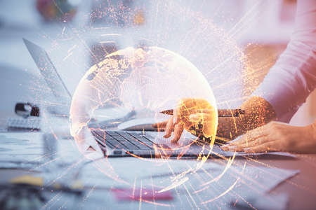 Double exposure of woman hands typing on computer and social network theme hologram drawing. People...