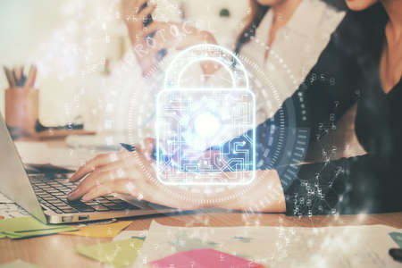 Double exposure of woman hands working on computer and lock hologram drawing. Security concept.