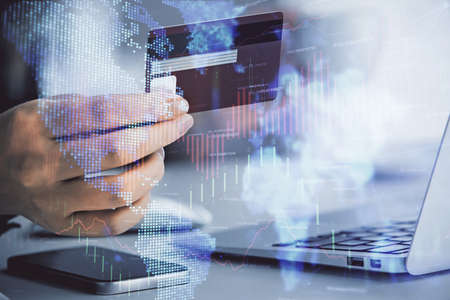 Multi exposure of woman on-line shopping holding a credit card and financial graph drawing. Stock...