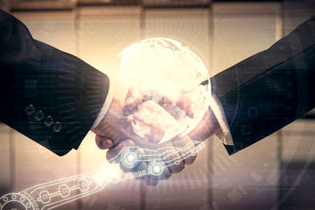 Double exposure of world map hologram and handshake of two men. International partnership concept.の写真素材