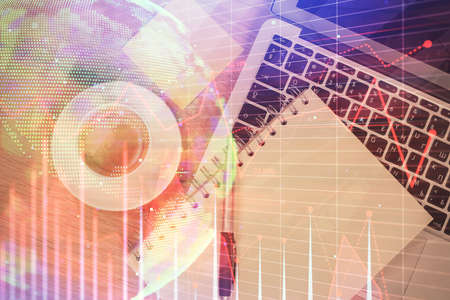 Double exposure of forex chart drawing over table background with computer. Concept of financial...