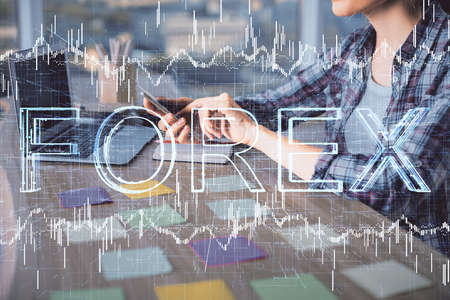 Double exposure of businesswoman hands typing on computer and forex graph hologram drawing....