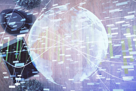 Double exposure of business theme hologram over desktop with phone. Top view. Mobile international...