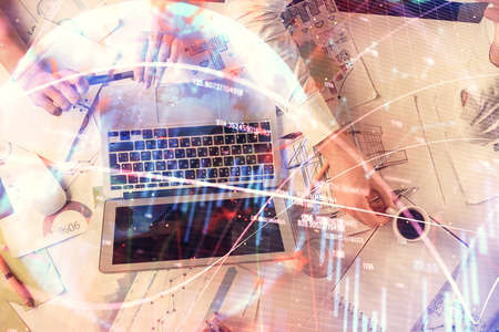 Double exposure of man and woman working together and financial graph hologram. Business concept....