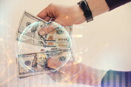 Double exposure of world map drawing hologram and us dollars bills and man hands.の写真素材