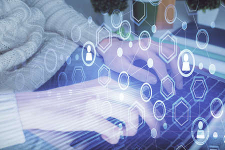 Double exposure of woman hands typing on computer and social network theme hologram drawing. People...