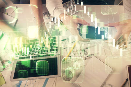 Multi exposure of man and woman working together and forex graph hologram drawing. Financial...