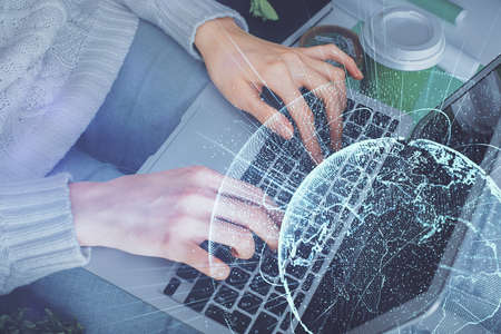 Double exposure of woman hands typing on computer and social network theme hologram drawing. People...