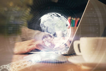 Double exposure of woman hands working on computer and world map hologram drawing. International...