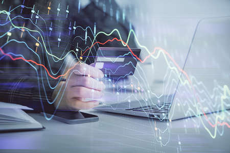 Multi exposure of woman on-line shopping holding a credit card and financial graph drawing. Stock...