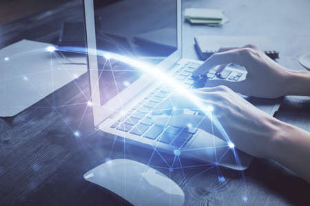 Double exposure of woman hands typing on computer and social network theme hologram drawing. People...