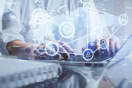Double exposure of woman hands typing on computer and social network theme hologram drawing. People...