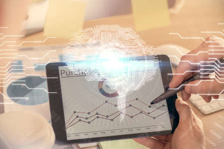 Double exposure of mans hand holding and using a digital device and brain hologram drawing. Data...