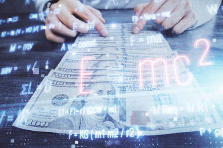 Multi exposure of Formulas drawing hologram and USA dollars bills and man hands. Educationの写真素材