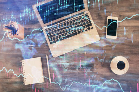 Double exposure of forex chart drawing over table background with computer. Concept of financial research and analysis. Top view.の写真素材