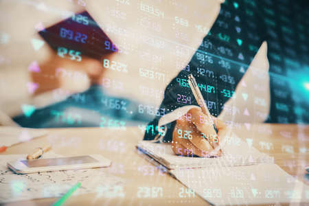 Double exposure of forex chart drawing over people taking notes background. Concept of financial analysisの写真素材