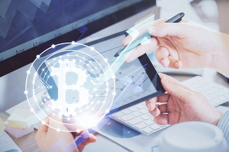 Double exposure of mans hands holding and using a phone and crypto currency blockchain theme...
