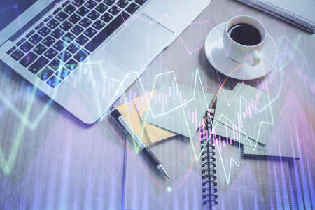 Stock market graph and top view computer on the table background. Double exposure. Concept of...