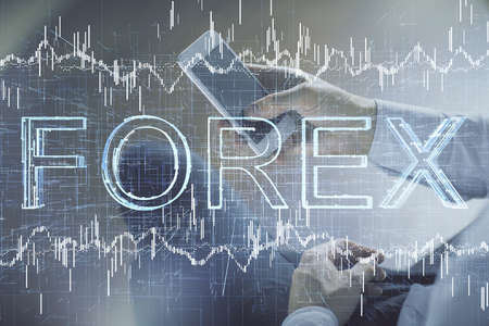 Double exposure of mans hands holding and using a digital device and forex graph drawing. Financial market concept.の写真素材