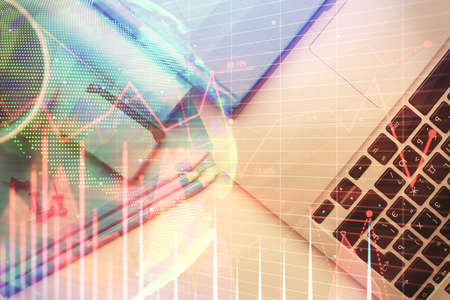 Double exposure of forex graph drawing over desktop background with computer. Concept of financial...