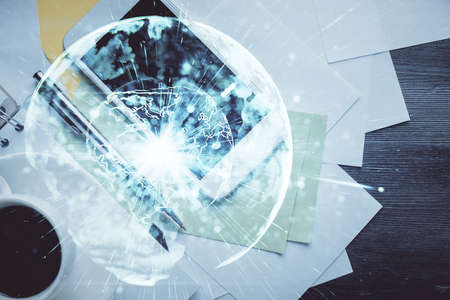 Double exposure of business theme hologram over desktop with phone. Top view. Mobile international trade connection concept.の写真素材
