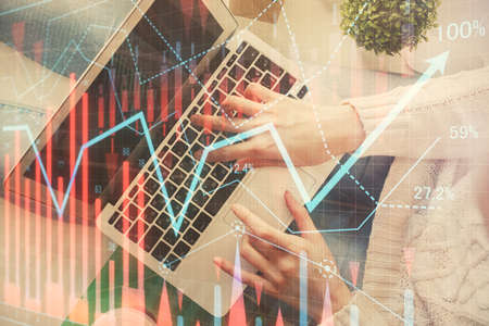 Double exposure of woman hands working on computer and forex chart hologram drawing. Top View....