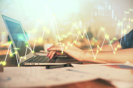 Double exposure of businesswoman hands typing on computer and forex chart hologram drawing....