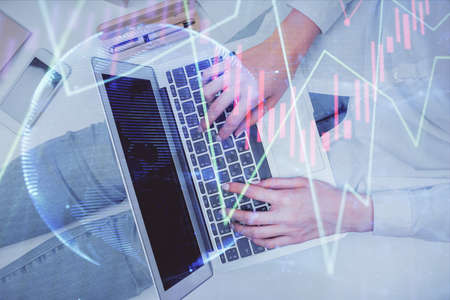 Double exposure of woman hands working on computer and forex graph hologram drawing. Top View....