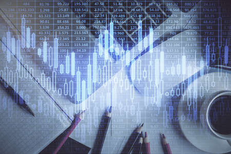 Double exposure of financial chart drawing over table background with computer. Concept of research and analysis. Top view.の写真素材