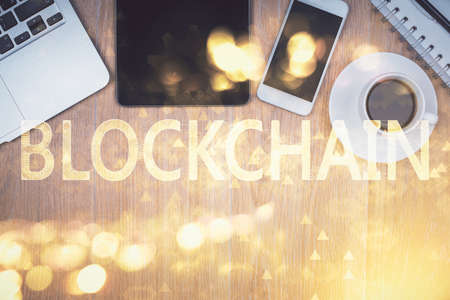 Double exposure of blockchain theme hologram over table with phone. Top view. Crypto technology concept.の写真素材