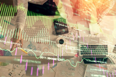 Double exposure of man and woman working together and financial graph hologram drawing. market...