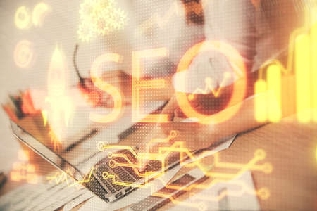 Double exposure of woman hands working on computer and seo hologram drawing. internet search concept.の写真素材