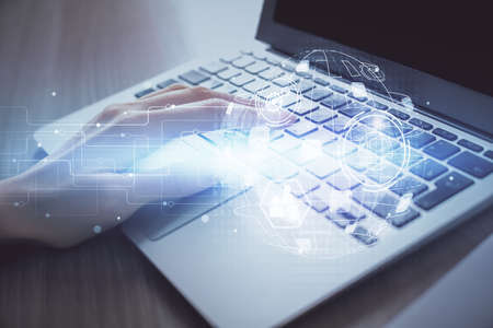 Double exposure of woman hands typing on computer and social network theme hologram drawing. People...
