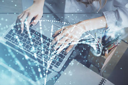Double exposure of woman hands typing on computer and DNA hologram drawing. Medical education...