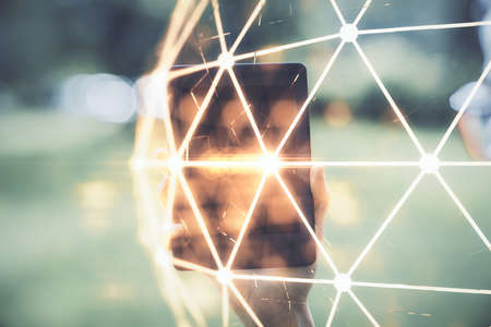 Double exposure of social network sketch hologram and woman holding and using a mobile device.の写真素材