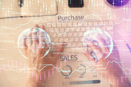 Double exposure of mans hands typing over laptop keyboard and forex chart hologram drawing. Top view. Financial markets concept.の写真素材