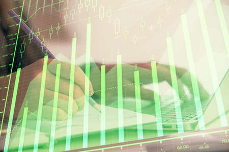 Double exposure of businesswoman hands typing on computer and forex chart hologram drawing....