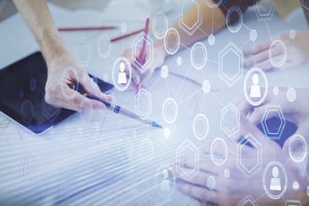 Double exposure of social network theme drawing and man and woman working together holding and using a mobile device.の写真素材