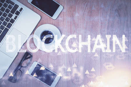 Double exposure of blockchain theme hologram over table with phone. Top view. Crypto technology concept.の写真素材