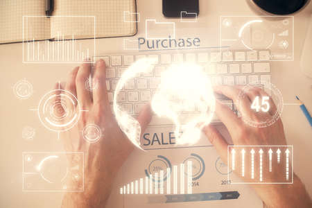 Double exposure of mans hands typing over laptop keyboard and forex chart hologram drawing. Top...