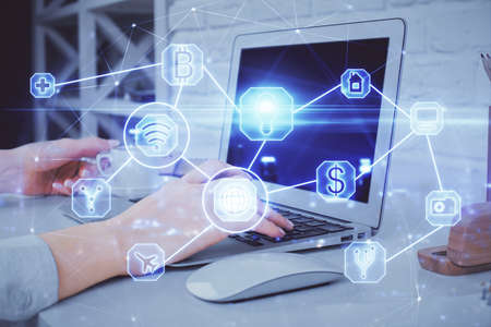 Double exposure of woman hands typing on computer and social network theme hologram drawing. People...