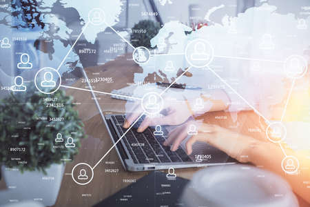 Double exposure of woman hands typing on computer and social network theme hologram drawing. People media concept.の写真素材
