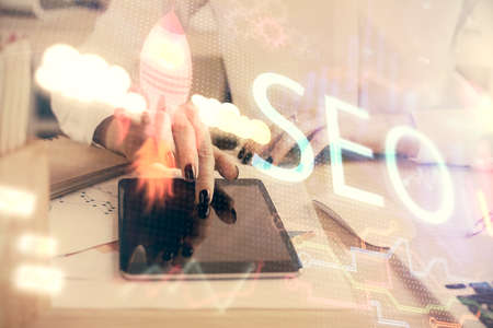 Double exposure of SEO sketch hologram and woman holding and using a mobile device.の写真素材