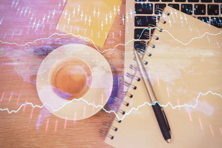 Double exposure of financial chart drawing over table background with computer. Concept of research and analysis. Top view.の写真素材