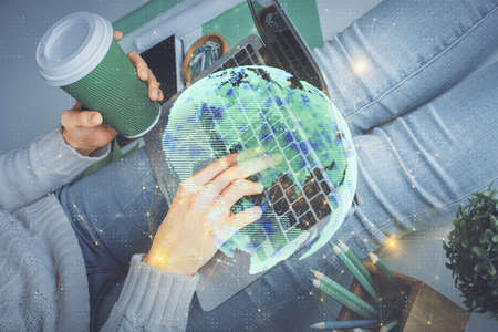 Double exposure of woman hands typing on computer and social network theme hologram drawing. People...