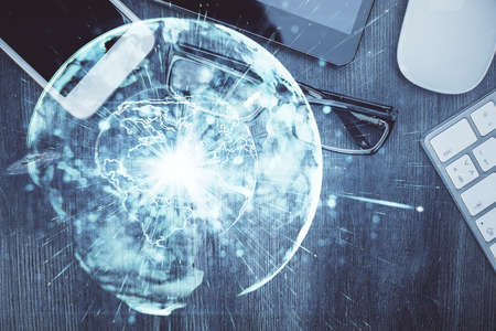 Double exposure of business theme hologram over desktop with phone. Top view. Mobile international...