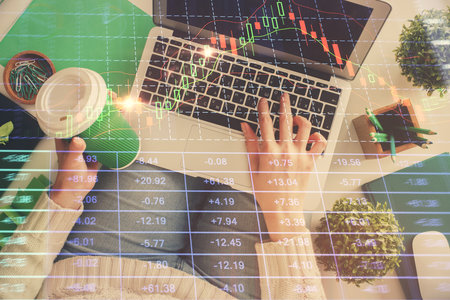 Double exposure of woman hands working on computer and forex chart hologram drawing. Top View....