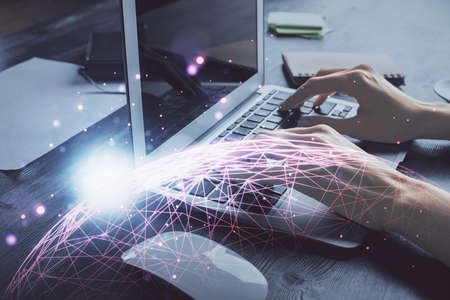 Double exposure of woman hands typing on computer and social network theme hologram drawing. People...