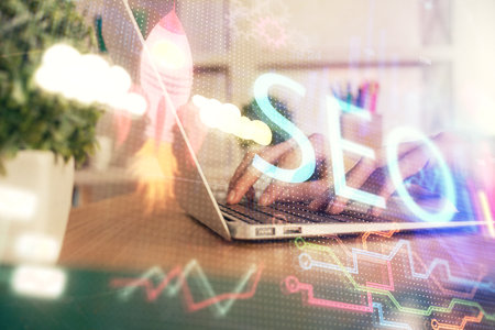 Double exposure of woman hands working on computer and seo hologram drawing. internet search concept.の写真素材